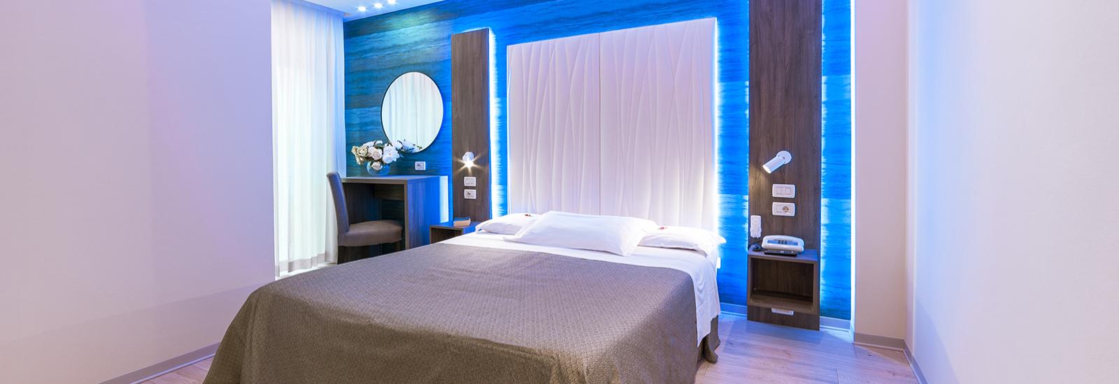 Modern room with blue lights and a double bed.